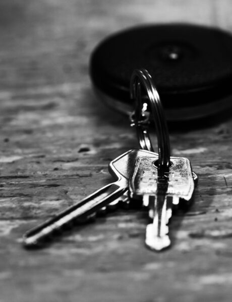Close-up of house keys on a keyring resting on a wooden surface