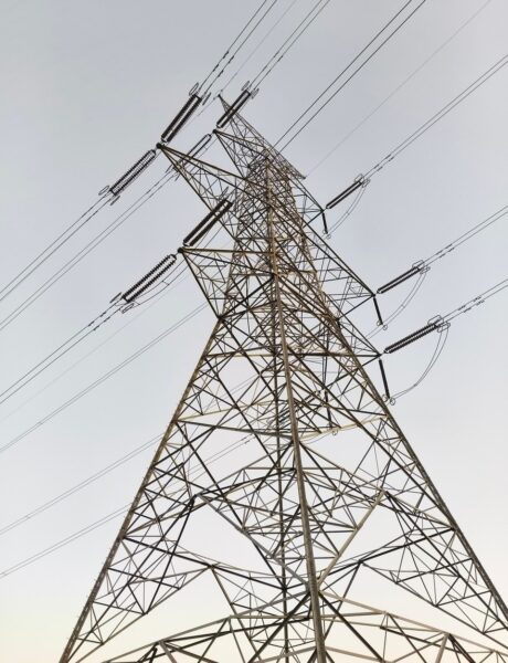 Electricity transmission pylon photographed from below against the sky