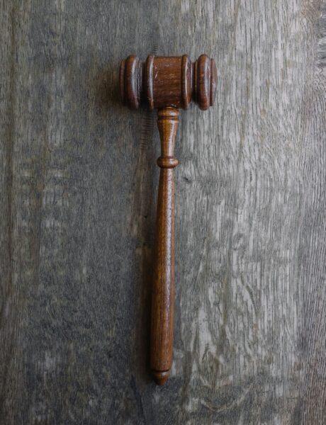 Wooden judge’s gavel on a textured wooden surface